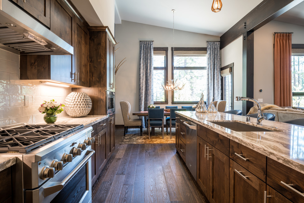 Transitional dark wood floor and brown floor open concept kitchen photo with an undermount sink, shaker cabinets, dark wood cabinets, quartz countertops, white backsplash, stainless steel appliances, an island and white countertops