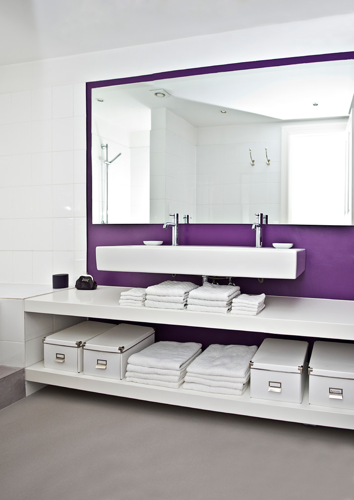 Inspiration for a large contemporary master bathroom in Hamburg with a wall-mount sink, open cabinets, white cabinets, white tile, ceramic tile, concrete floors, a drop-in tub and purple walls.
