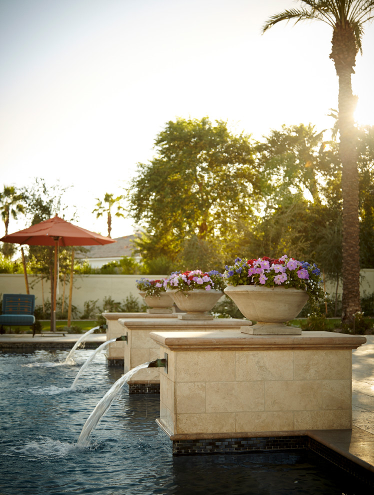 This is an example of a large mediterranean rectangular pool in Phoenix with a water feature.