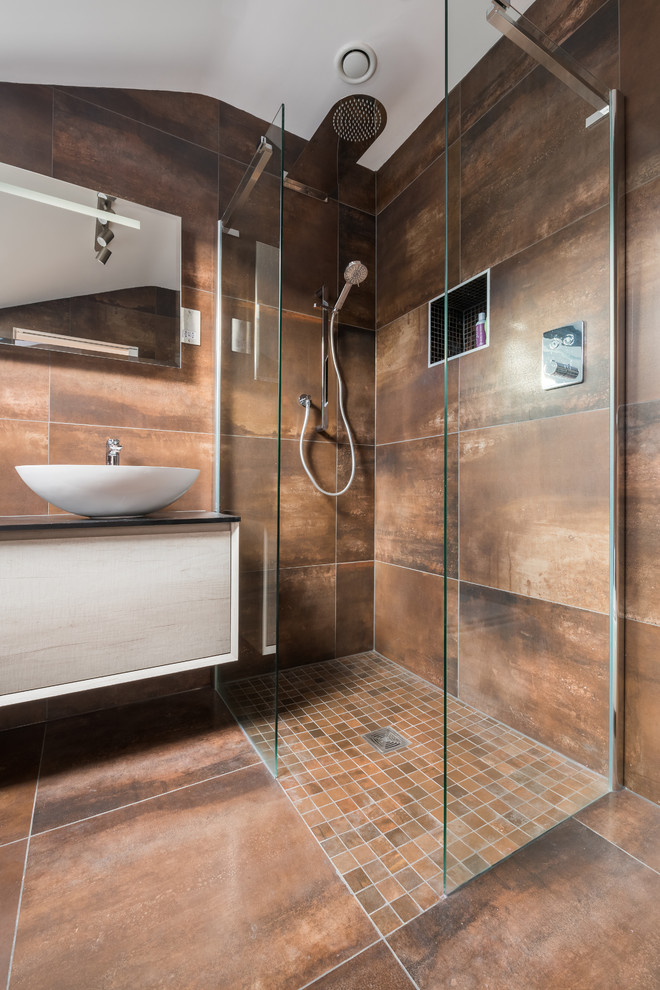 Inspiration for a contemporary master bathroom in Other with flat-panel cabinets, distressed cabinets, a corner shower, a vessel sink, an open shower, brown tile, brown walls and brown floor.