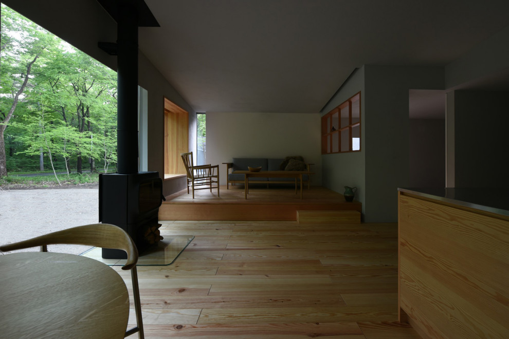 Идея дизайна: маленькая открытая гостиная комната в скандинавском стиле с серыми стенами, светлым паркетным полом, печью-буржуйкой и бежевым полом без телевизора для на участке и в саду