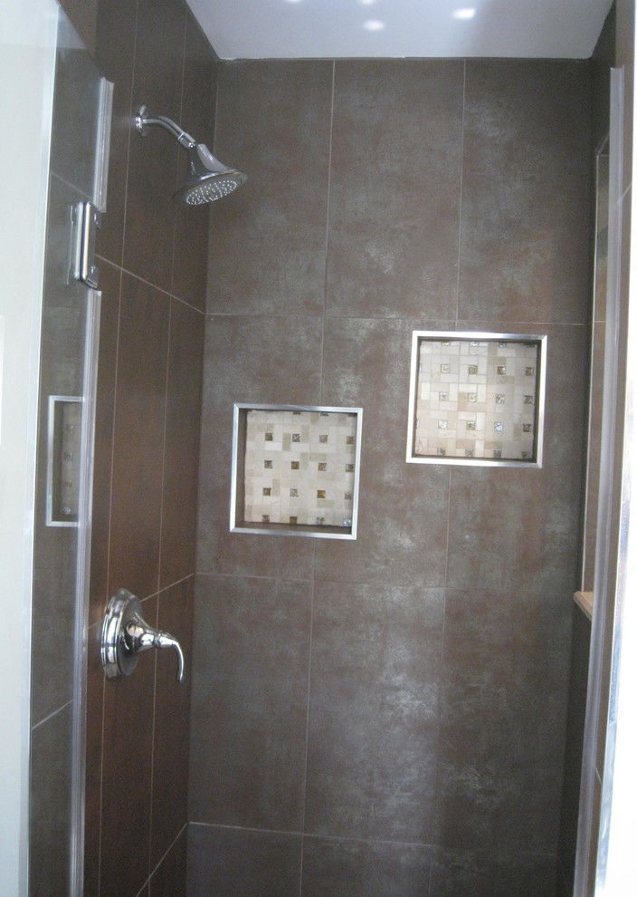 This is an example of a large traditional bathroom in DC Metro with an alcove shower, brown tile, stone tile, brown walls and ceramic floors.