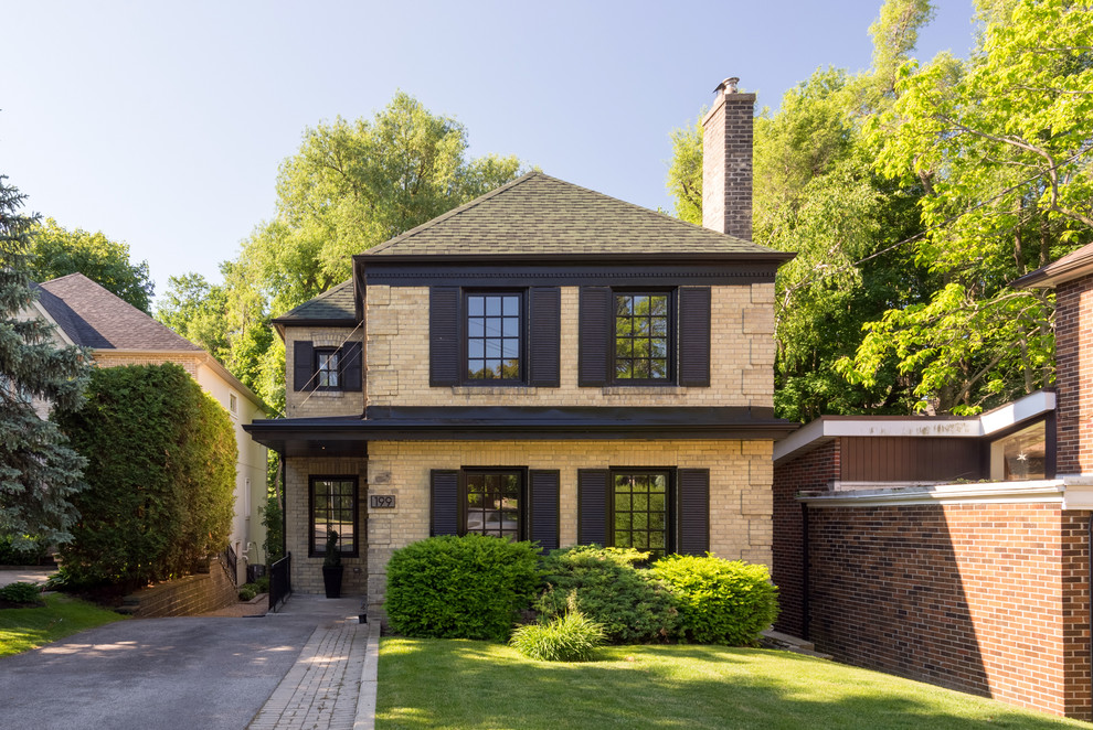 Design ideas for a mid-sized contemporary two-storey brick yellow exterior in Toronto with a hip roof.