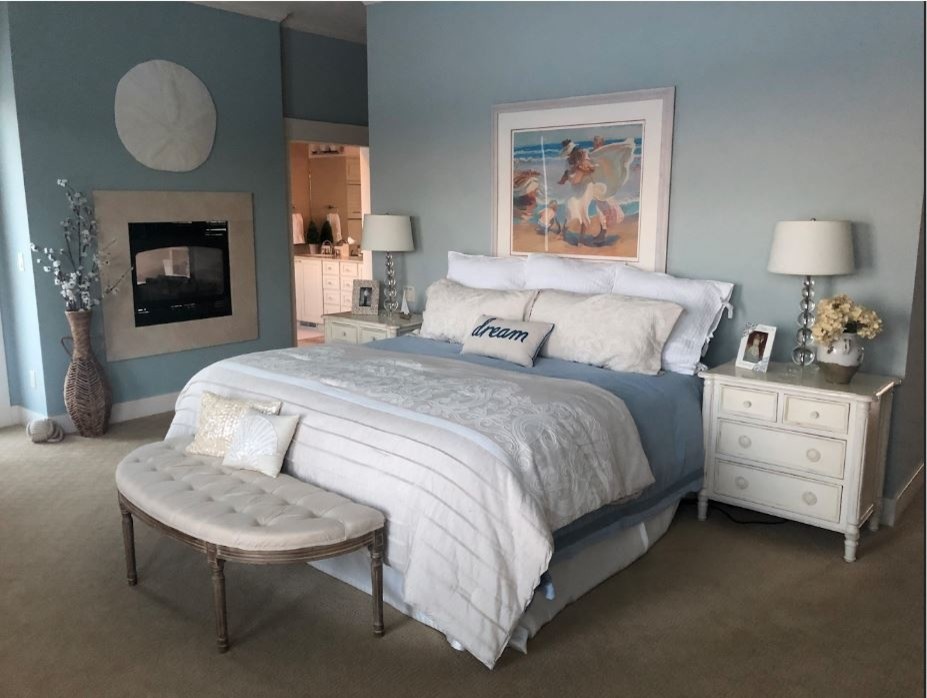 Inspiration for a large transitional master bedroom in Minneapolis with blue walls, carpet, a two-sided fireplace, a stone fireplace surround and beige floor.