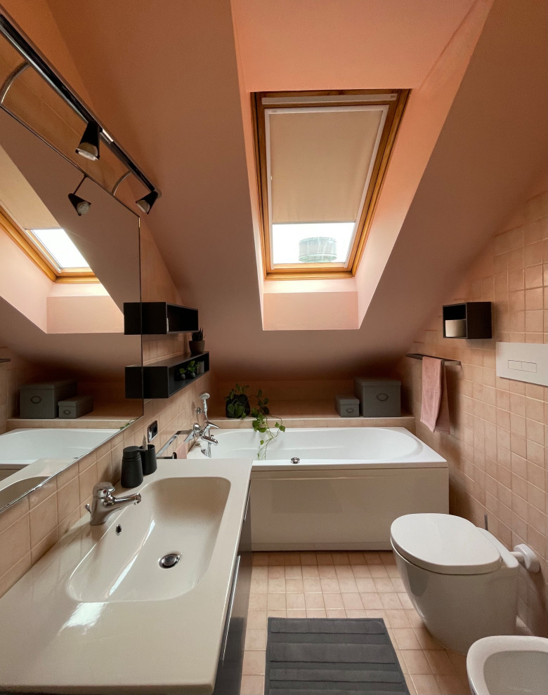 Exempel på ett mellanstort modernt badrum, med släta luckor, ett fristående badkar, en toalettstol med hel cisternkåpa, rosa kakel, porslinskakel, rosa väggar, klinkergolv i porslin, ett undermonterad handfat och rosa golv