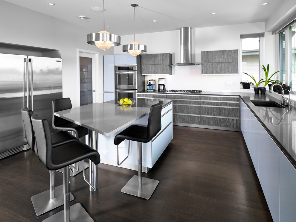 Design ideas for a modern kitchen in Edmonton with stainless steel appliances, brown floor and black benchtop.