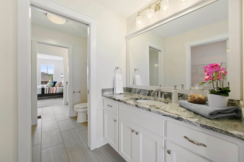 Photo of a large kids bathroom in Minneapolis with white cabinets, white walls, ceramic floors and granite benchtops.