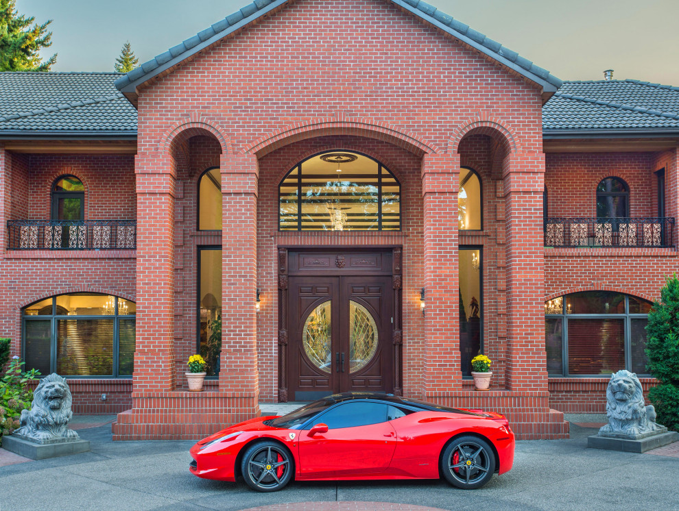 Photo of an expansive three-storey brick house exterior in Seattle with a hip roof, a tile roof and a black roof.