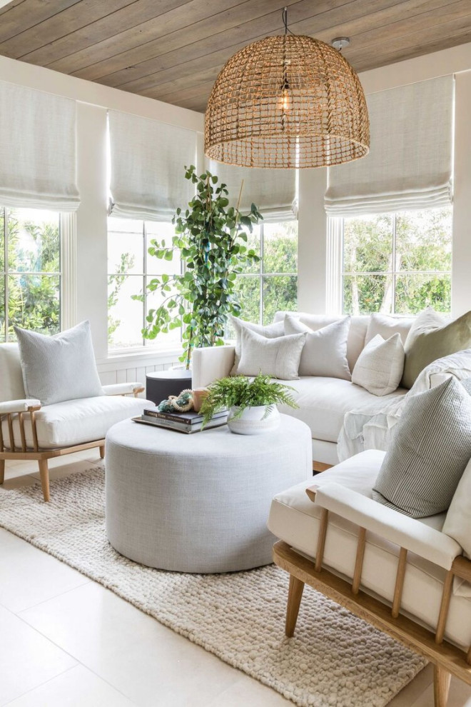 This is an example of a beach style living room in Orange County with white walls, beige floor and wood.