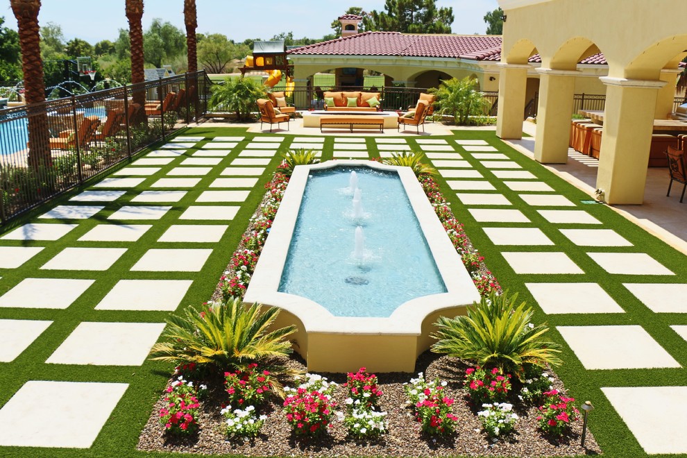 Expansive mediterranean courtyard full sun garden in Phoenix with a garden path and concrete pavers for spring.