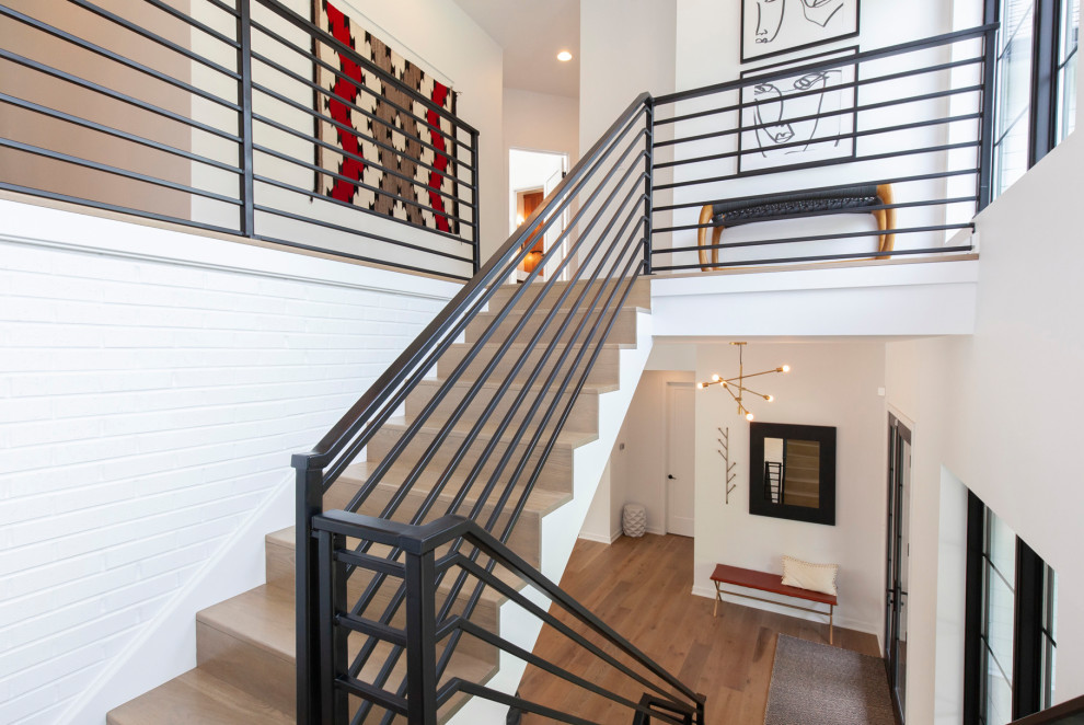 Photo of a large modern wood straight staircase in Chicago with wood risers, metal railing and planked wall panelling.