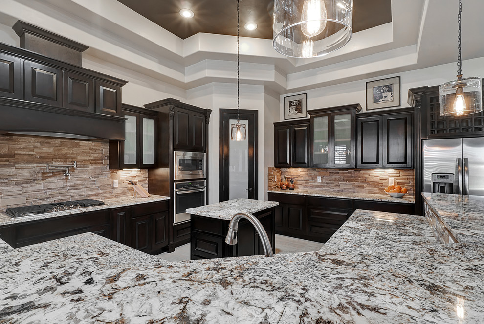 Example of a large transitional ceramic tile eat-in kitchen design in Austin with recessed-panel cabinets, black cabinets, granite countertops, brown backsplash, stone tile backsplash, stainless steel appliances and an island