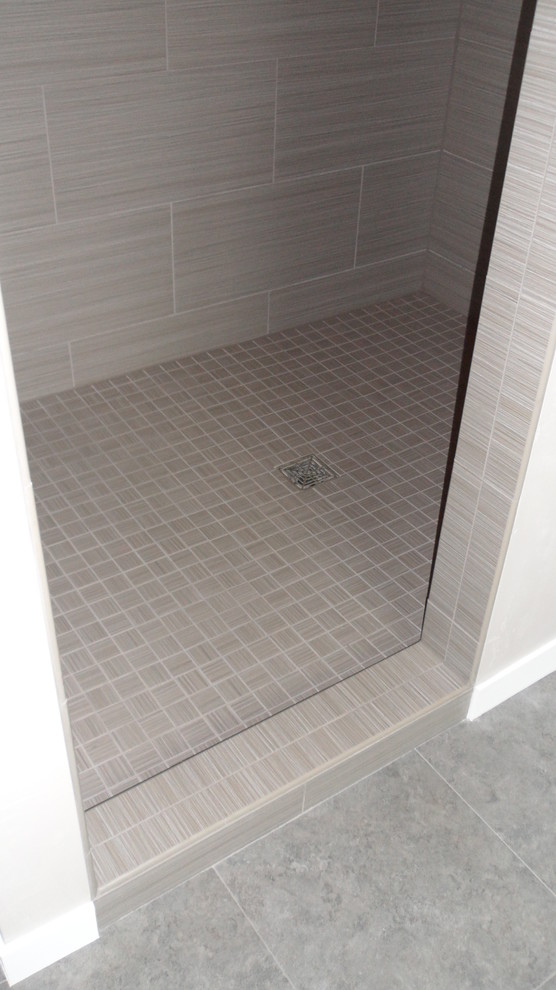 Example of a trendy master gray tile and glass tile vinyl floor doorless shower design in Other