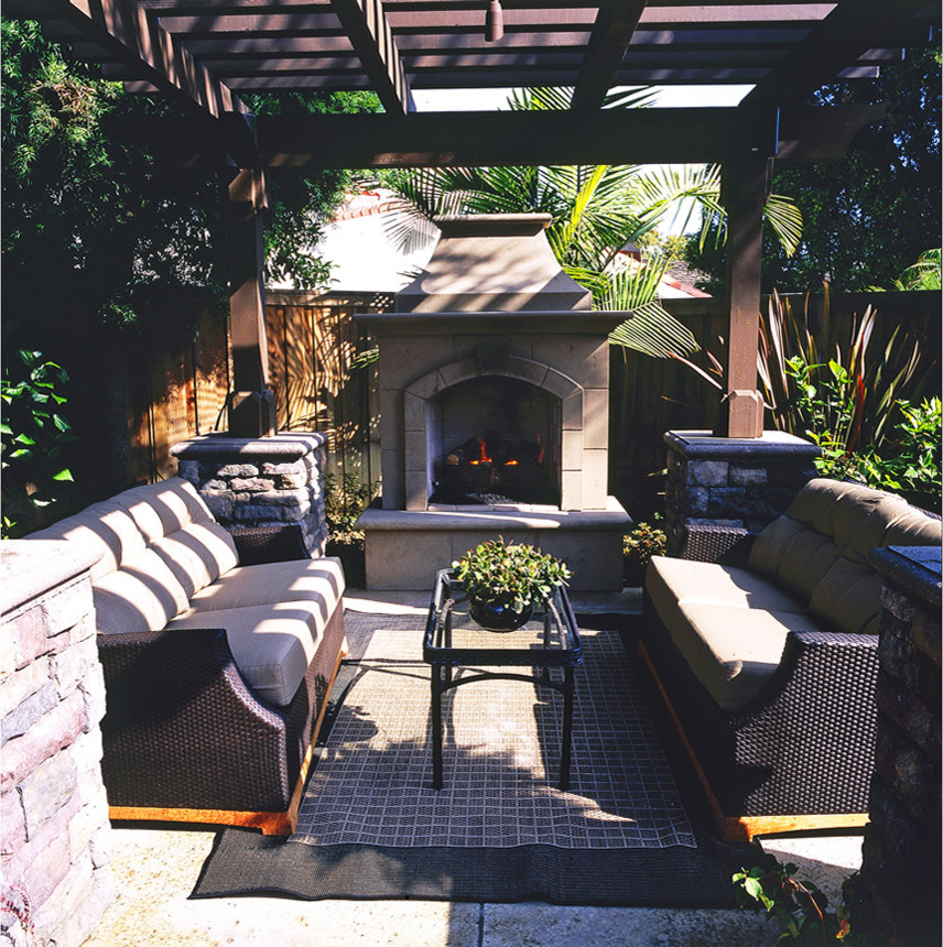 Photo of an expansive tropical side yard patio in Orange County with an outdoor kitchen, concrete slab and a roof extension.