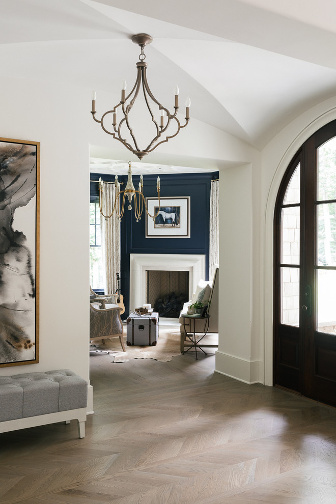 Inspiration for a large transitional formal enclosed living room in Atlanta with blue walls, light hardwood floors, a standard fireplace, a plaster fireplace surround, no tv and beige floor.