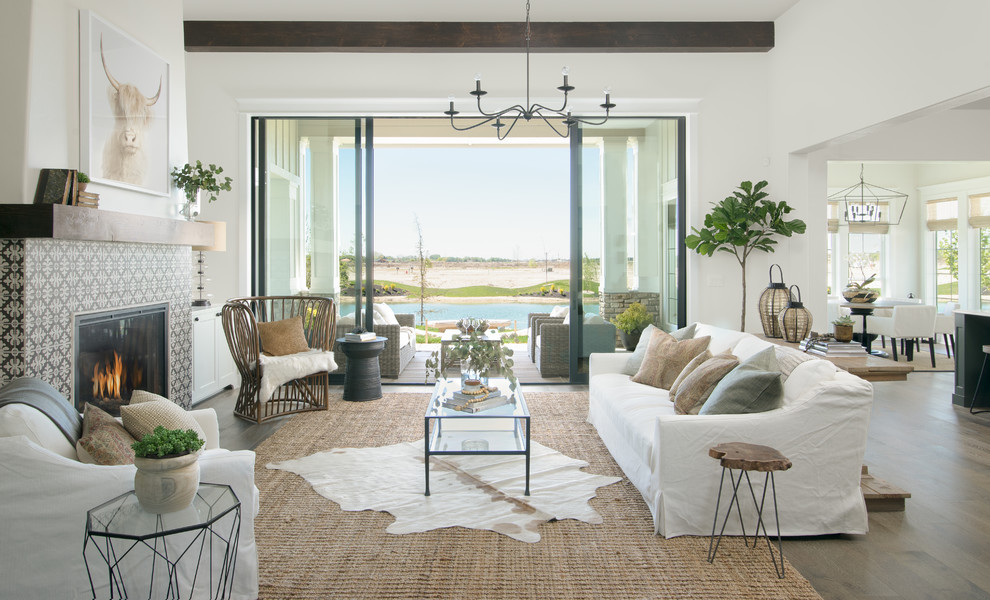 Photo of a beach style open concept living room in Boise with white walls, dark hardwood floors, a standard fireplace, a tile fireplace surround and brown floor.