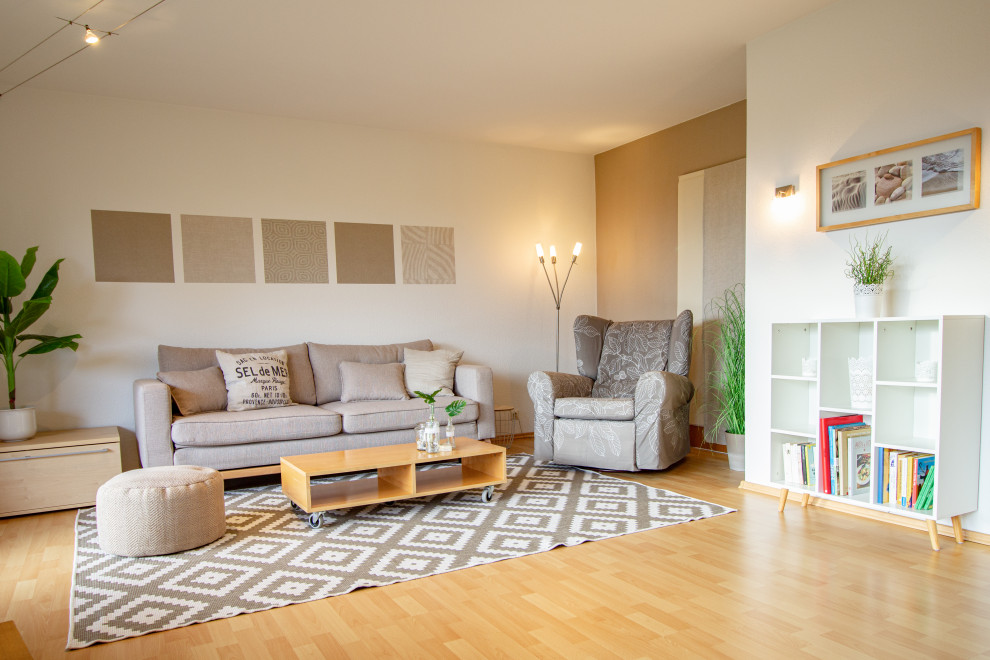 Photo of a large scandinavian family room in Stuttgart with beige walls, laminate floors, beige floor and wallpaper.
