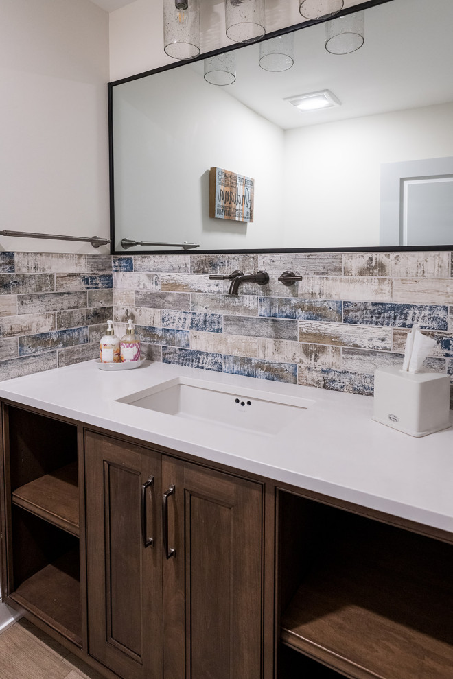 Photo of a mid-sized contemporary powder room in Indianapolis with white walls, medium hardwood floors, an undermount sink, granite benchtops, white benchtops and a built-in vanity.