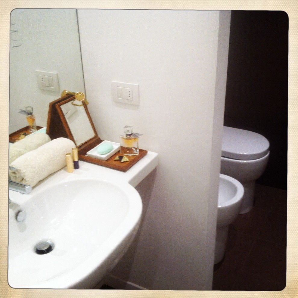 Inspiration pour une petite salle d'eau design avec des carreaux de porcelaine et un lavabo suspendu.