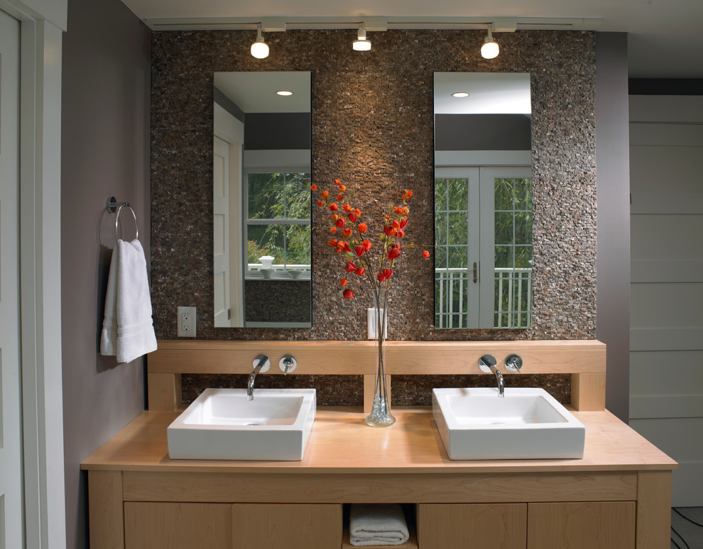 This is an example of a large contemporary master bathroom in Boston with flat-panel cabinets, light wood cabinets, an alcove tub, an alcove shower, gray tile, cement tile, grey walls, cement tiles, a vessel sink and wood benchtops.