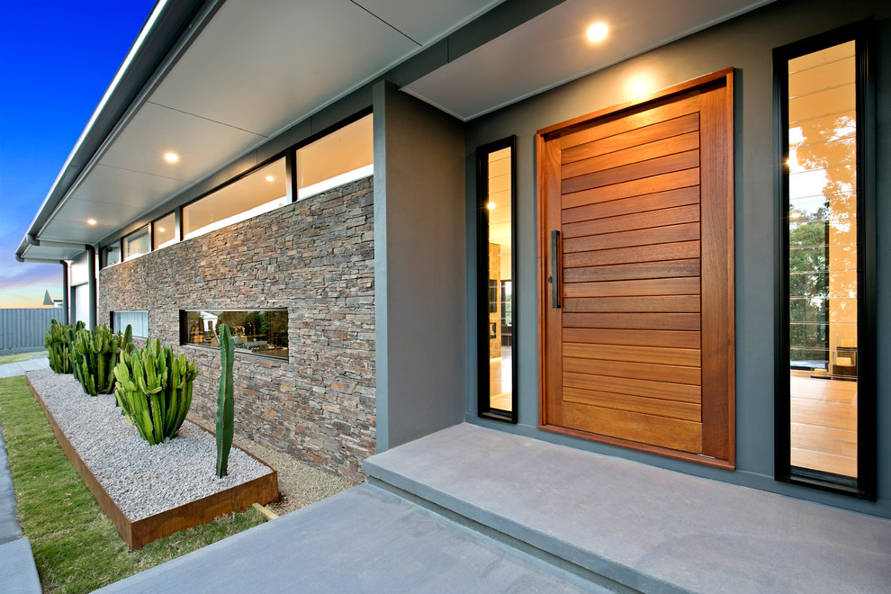 Inspiration for a midcentury split-level house exterior in Sunshine Coast with stone veneer.