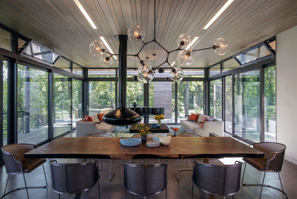 Contemporary open plan dining in New York with concrete floors and a hanging fireplace.