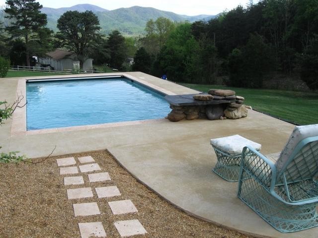 Inspiration for a backyard concrete paver and custom-shaped lap pool remodel