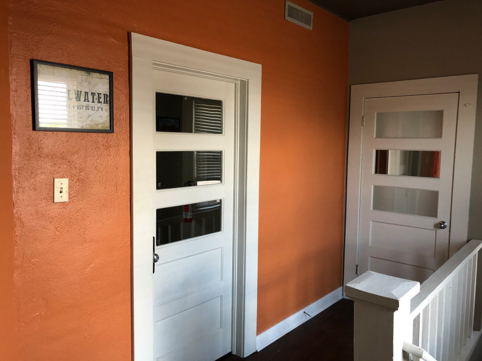 オクラホマシティにある低価格の中くらいなトランジショナルスタイルのおしゃれな玄関ロビー (オレンジの壁、クッションフロア、茶色い床) の写真