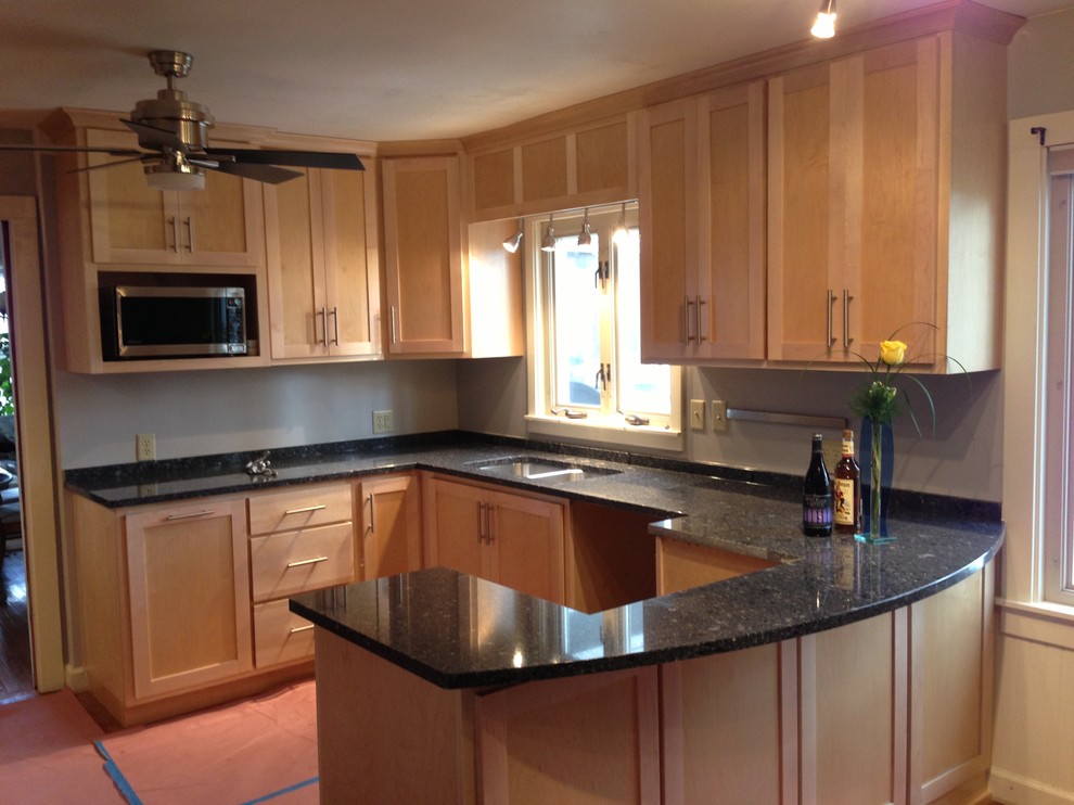 Example of a small transitional u-shaped medium tone wood floor enclosed kitchen design in Chicago with a double-bowl sink, shaker cabinets, light wood cabinets, quartzite countertops, stainless steel appliances and a peninsula