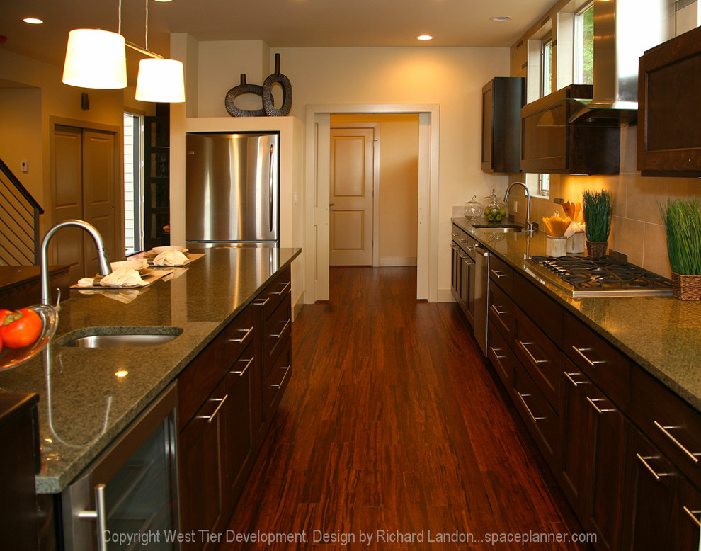 This is an example of a large contemporary l-shaped eat-in kitchen in Seattle with a double-bowl sink, recessed-panel cabinets, dark wood cabinets, granite benchtops, beige splashback, ceramic splashback, stainless steel appliances, medium hardwood floors and with island.