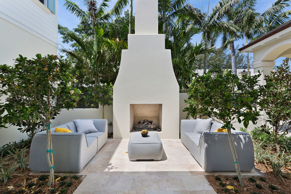 Small backyard patio in Miami with with fireplace, concrete pavers and no cover.