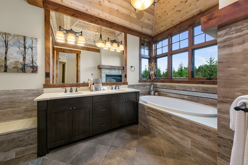 Country master bathroom in Seattle with recessed-panel cabinets, dark wood cabinets, a hot tub, beige tile, white walls, porcelain floors, an undermount sink, quartzite benchtops, brown floor and a hinged shower door.