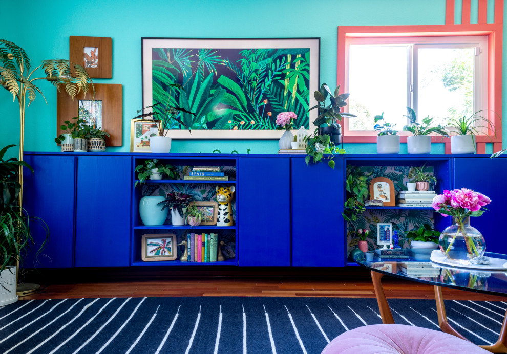 Ispirazione per un soggiorno tropicale di medie dimensioni e chiuso con pareti blu, pavimento in legno massello medio, TV a parete, pannellatura e pavimento rosso