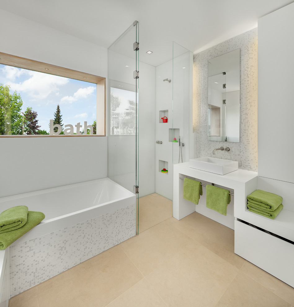 This is an example of a contemporary bathroom in Munich with a vessel sink, open cabinets, white cabinets, a drop-in tub, a corner shower, gray tile, white tile, mosaic tile, solid surface benchtops and white walls.