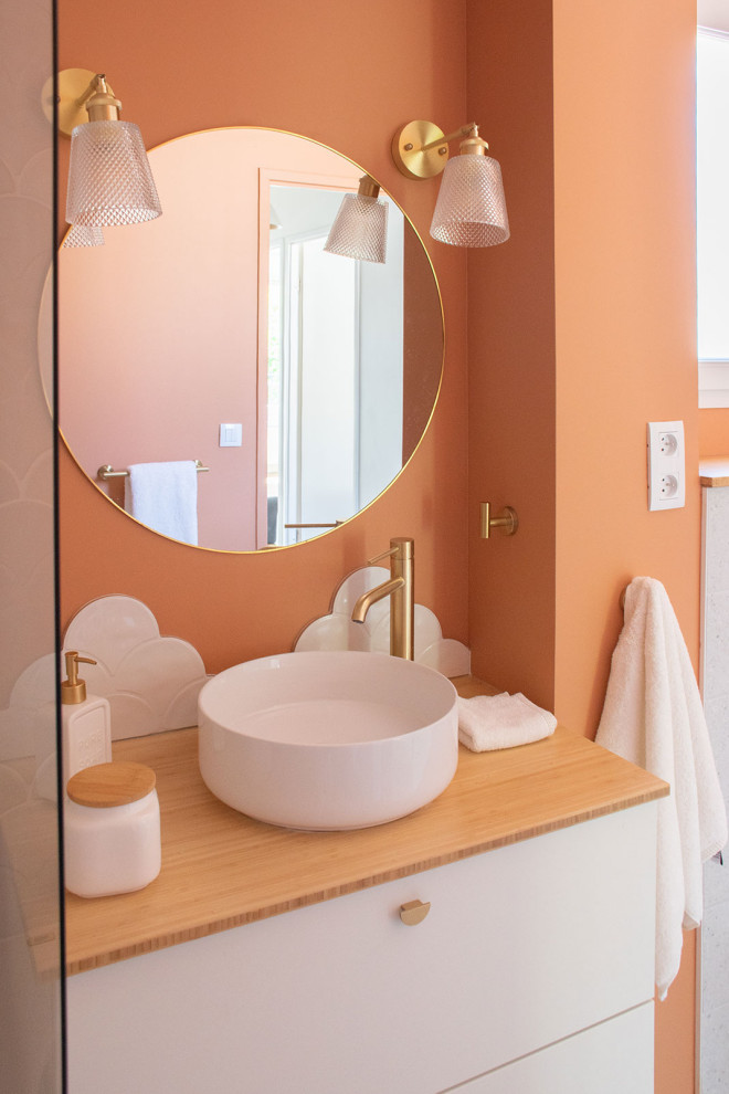 Exemple d'une petite salle de bain moderne pour enfant avec une baignoire encastrée, WC suspendus, un carrelage blanc, des carreaux de céramique, un mur orange, un sol en terrazzo, un plan de toilette en bois, un sol gris, une fenêtre et meuble simple vasque.