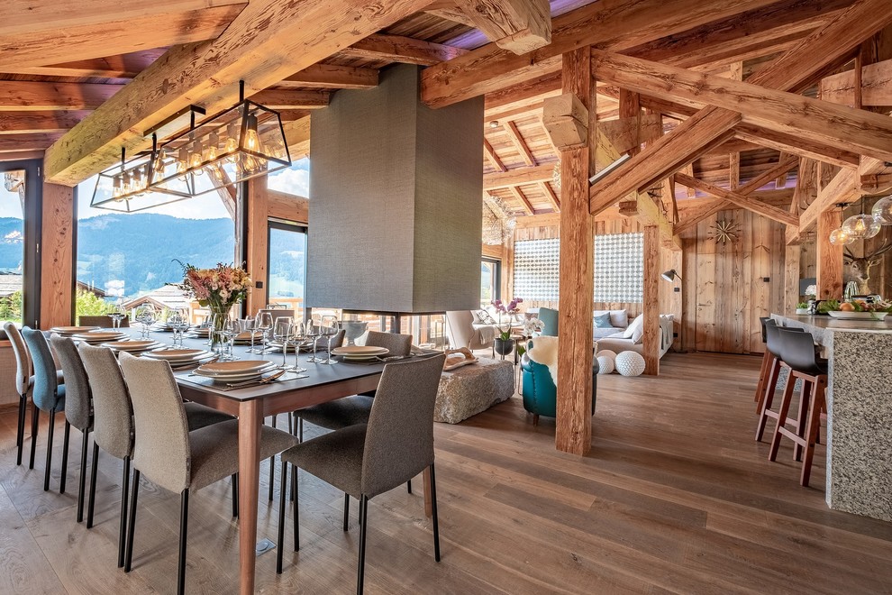 Country open plan dining in Grenoble with brown walls, dark hardwood floors and brown floor.
