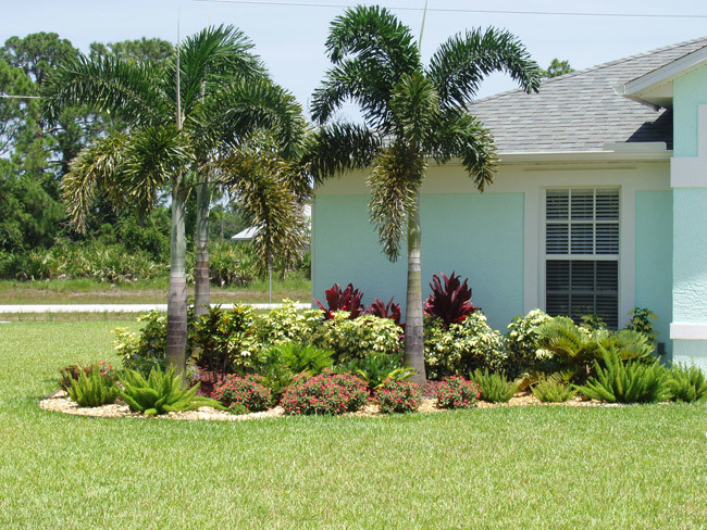 Photo of a mid-sized beach style front yard full sun formal garden for summer in Miami with gravel and a garden path.