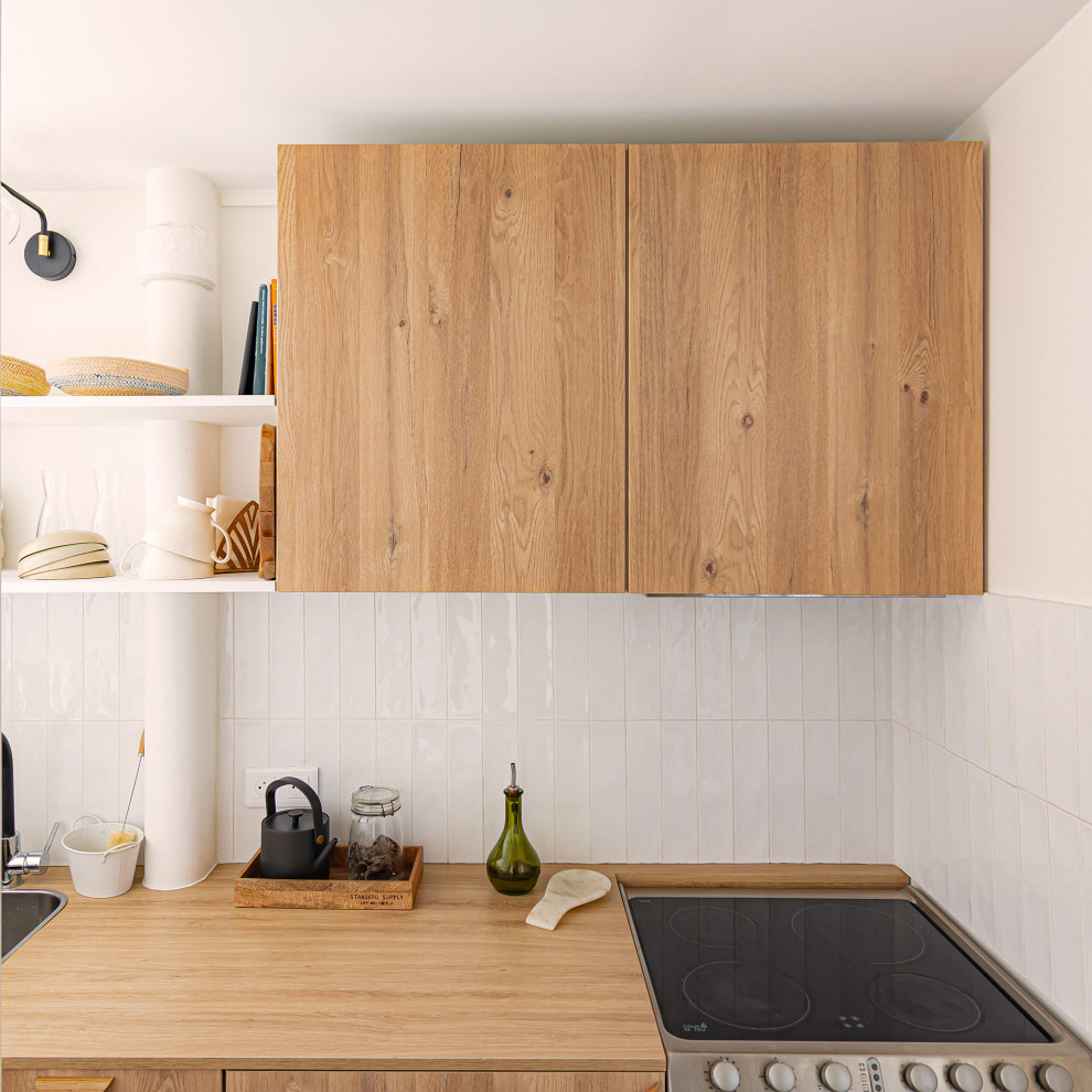 Photo of a small scandi single-wall kitchen/diner in Paris with a single-bowl sink, flat-panel cabinets, light wood cabinets, laminate countertops, white splashback, matchstick tiled splashback, stainless steel appliances, light hardwood flooring and no island.