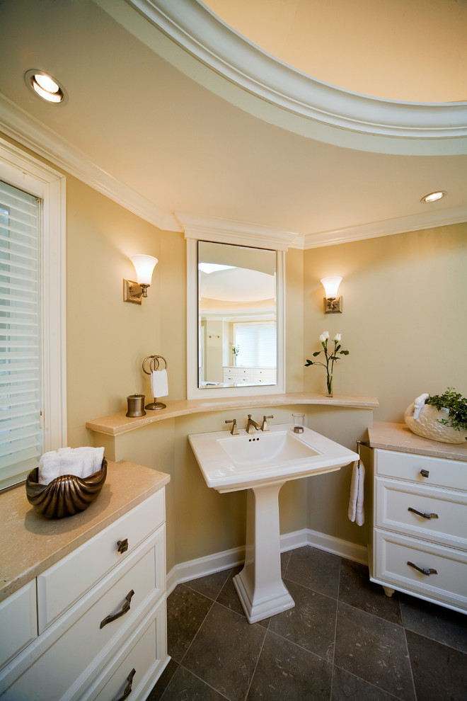 This is an example of a traditional bathroom in Milwaukee with marble benchtops and a pedestal sink.