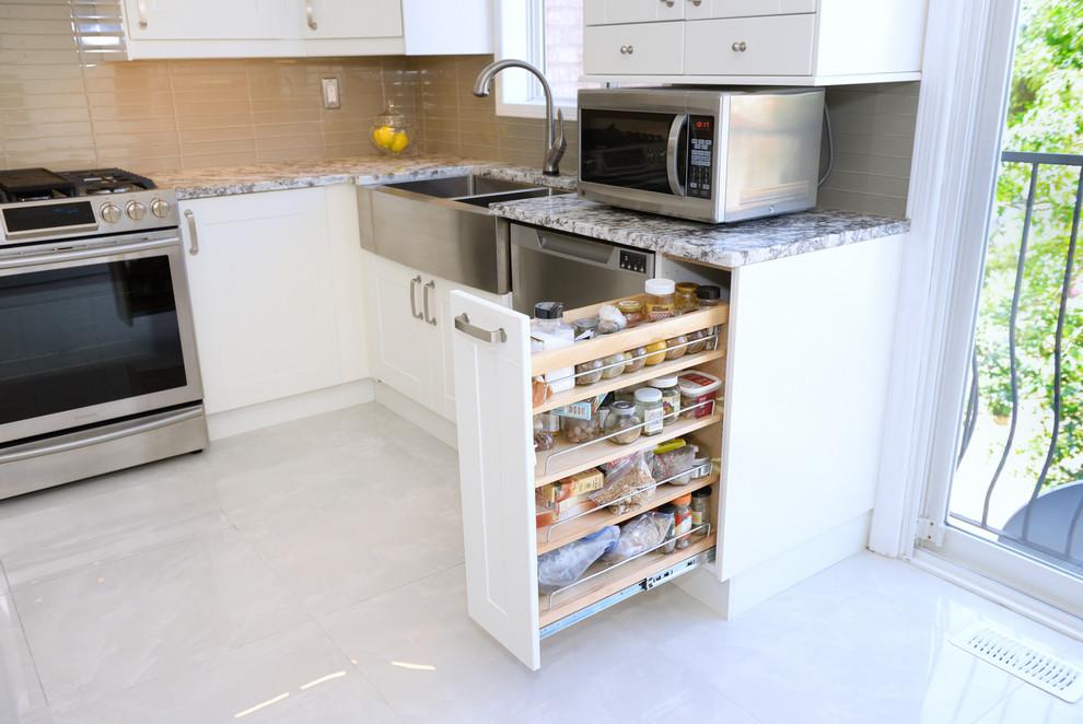 Inspiration for a large transitional u-shaped porcelain tile enclosed kitchen remodel in Toronto with a farmhouse sink, white cabinets, beige backsplash, stainless steel appliances, no island, recessed-panel cabinets, quartzite countertops and ceramic backsplash