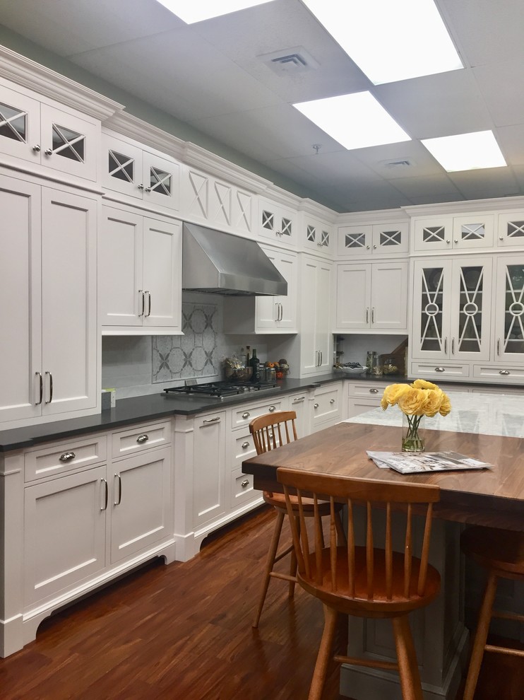 Example of a transitional kitchen design in Boston with shaker cabinets, white cabinets, quartz countertops, white backsplash, subway tile backsplash and an island