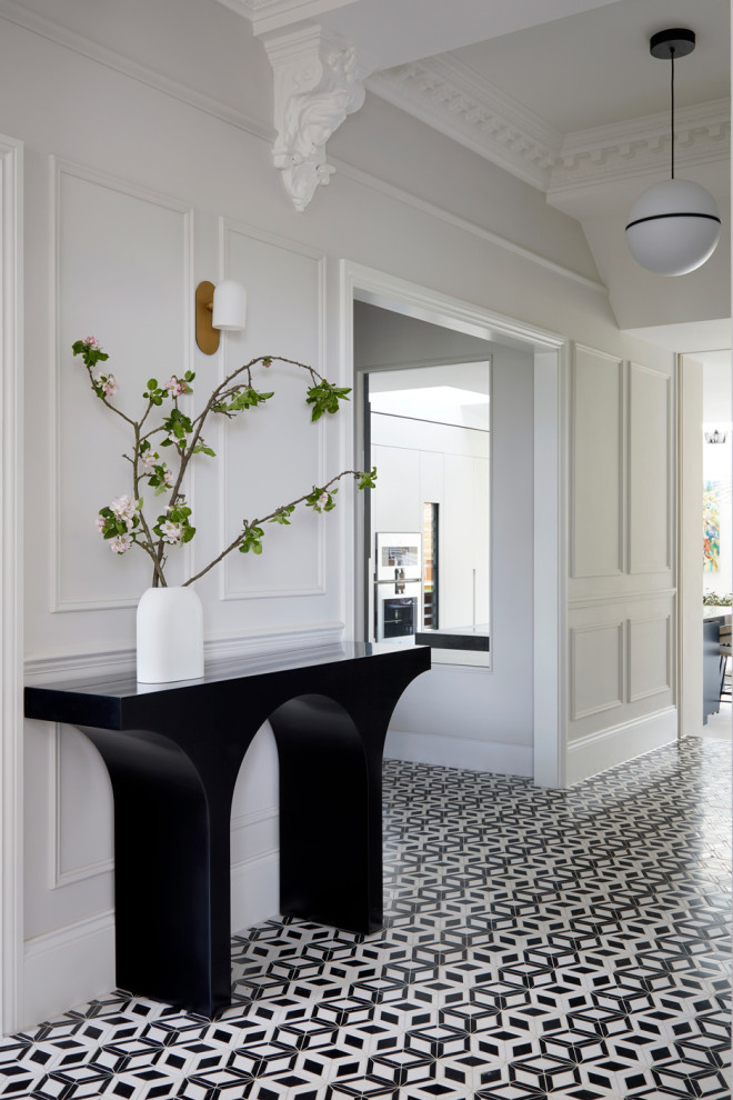 Photo of an expansive contemporary hallway in London with white walls, ceramic flooring, a single front door, a black front door, black floors and a dado rail.