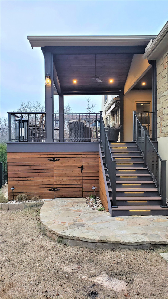Large mountain style backyard second story metal railing deck photo in Austin with a roof extension