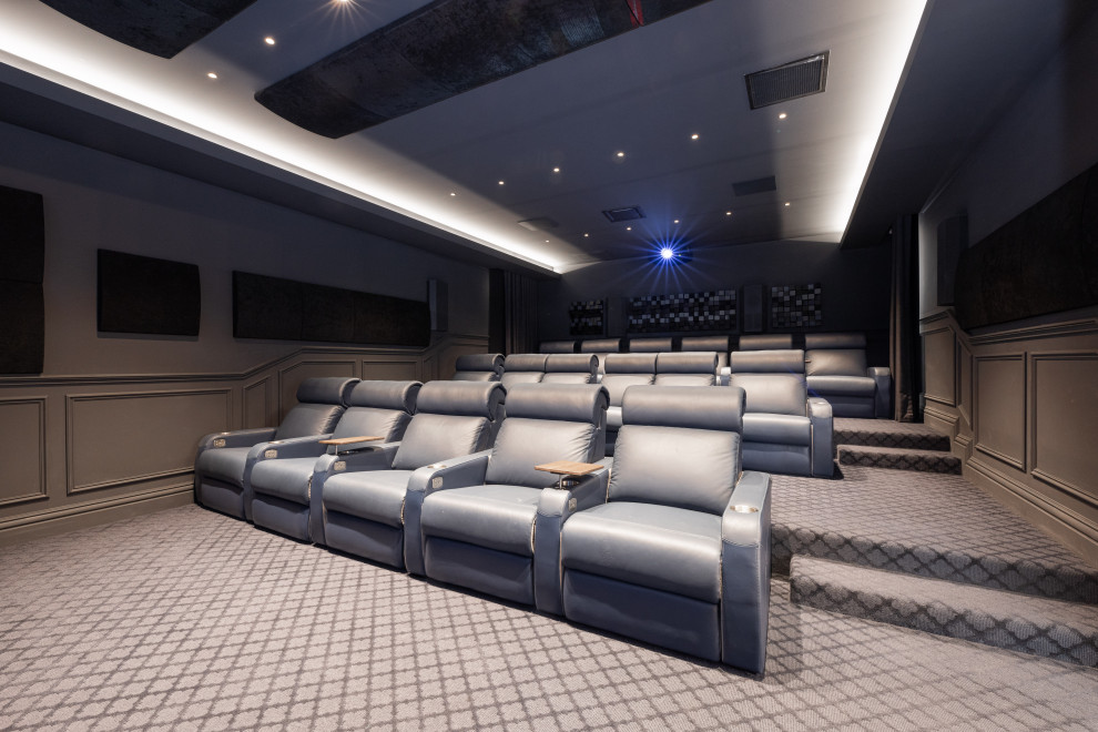 Imagen de cine en casa clásico extra grande con paredes negras, moqueta, pantalla de proyección y suelo azul