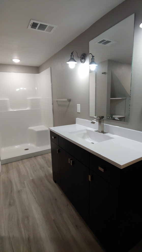 Bild på ett litet vintage vit vitt badrum med dusch, med släta luckor, svarta skåp, en dusch i en alkov, grå väggar, vinylgolv, ett integrerad handfat, bänkskiva i akrylsten, grått golv och dusch med duschdraperi