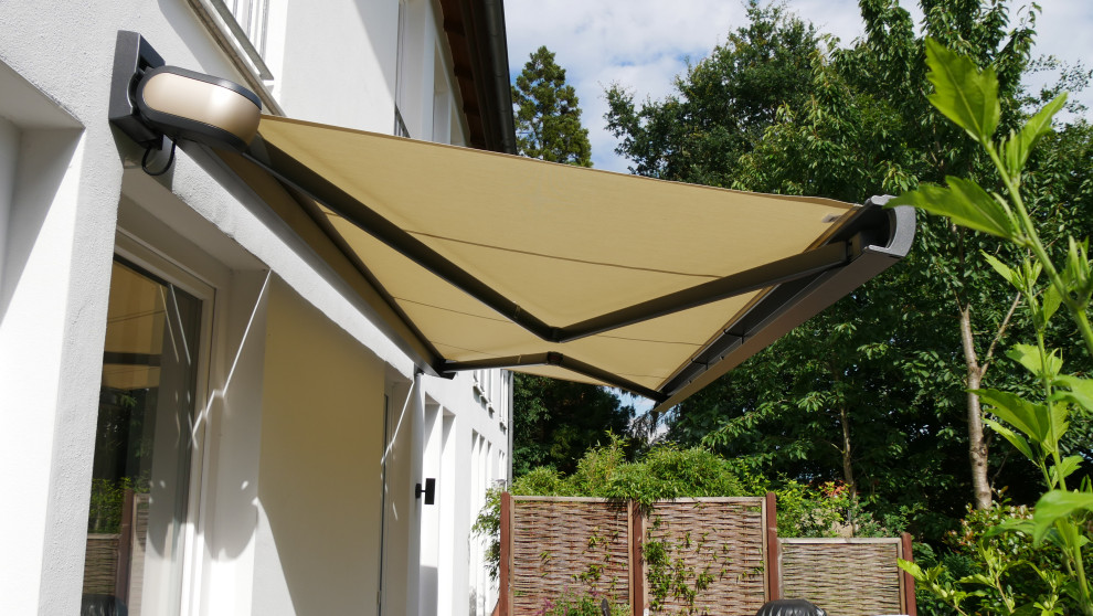 Ispirazione per un piccolo patio o portico mediterraneo dietro casa con un parasole