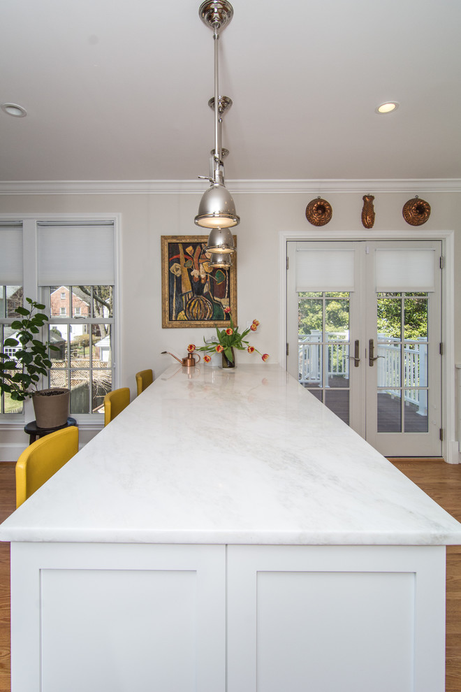 Inspiration for a mid-sized contemporary galley open plan kitchen in DC Metro with a farmhouse sink, white cabinets, marble benchtops, white splashback, porcelain splashback, stainless steel appliances, medium hardwood floors and with island.