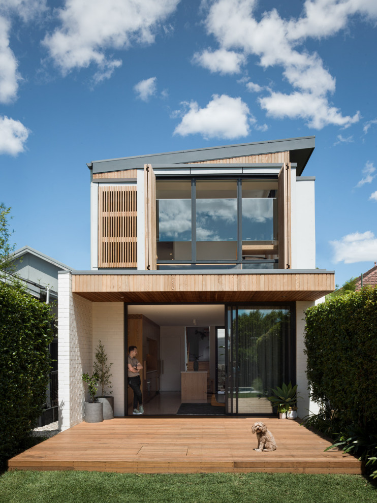 Design ideas for a contemporary two-storey white house exterior in Sydney with a shed roof.