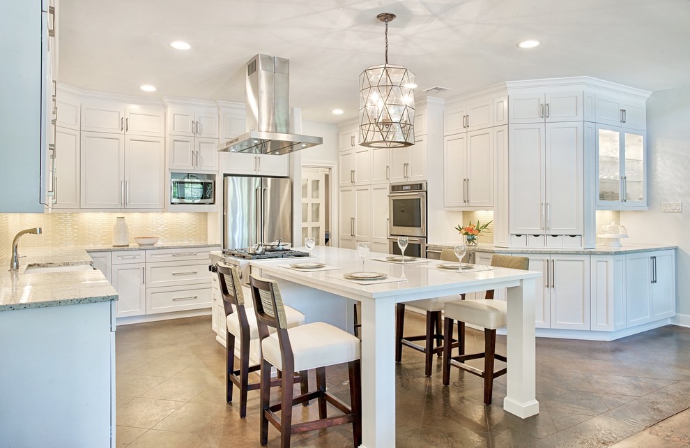 Transitional u-shaped brown floor kitchen photo in Austin with a farmhouse sink, recessed-panel cabinets, white cabinets, beige backsplash, stainless steel appliances and an island
