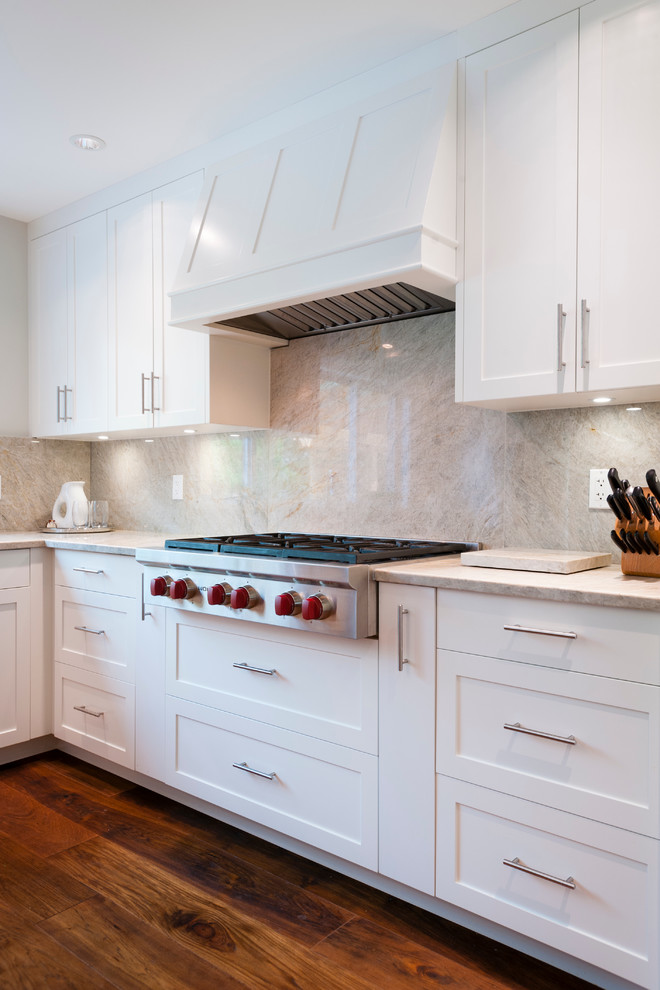 Large transitional l-shaped open plan kitchen in Vancouver with an undermount sink, shaker cabinets, white cabinets, quartzite benchtops, grey splashback, stone slab splashback, stainless steel appliances, medium hardwood floors and with island.